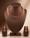 AD stone and freshwater pearl choker set with red American Diamond stones, pearl drops, and matching earrings