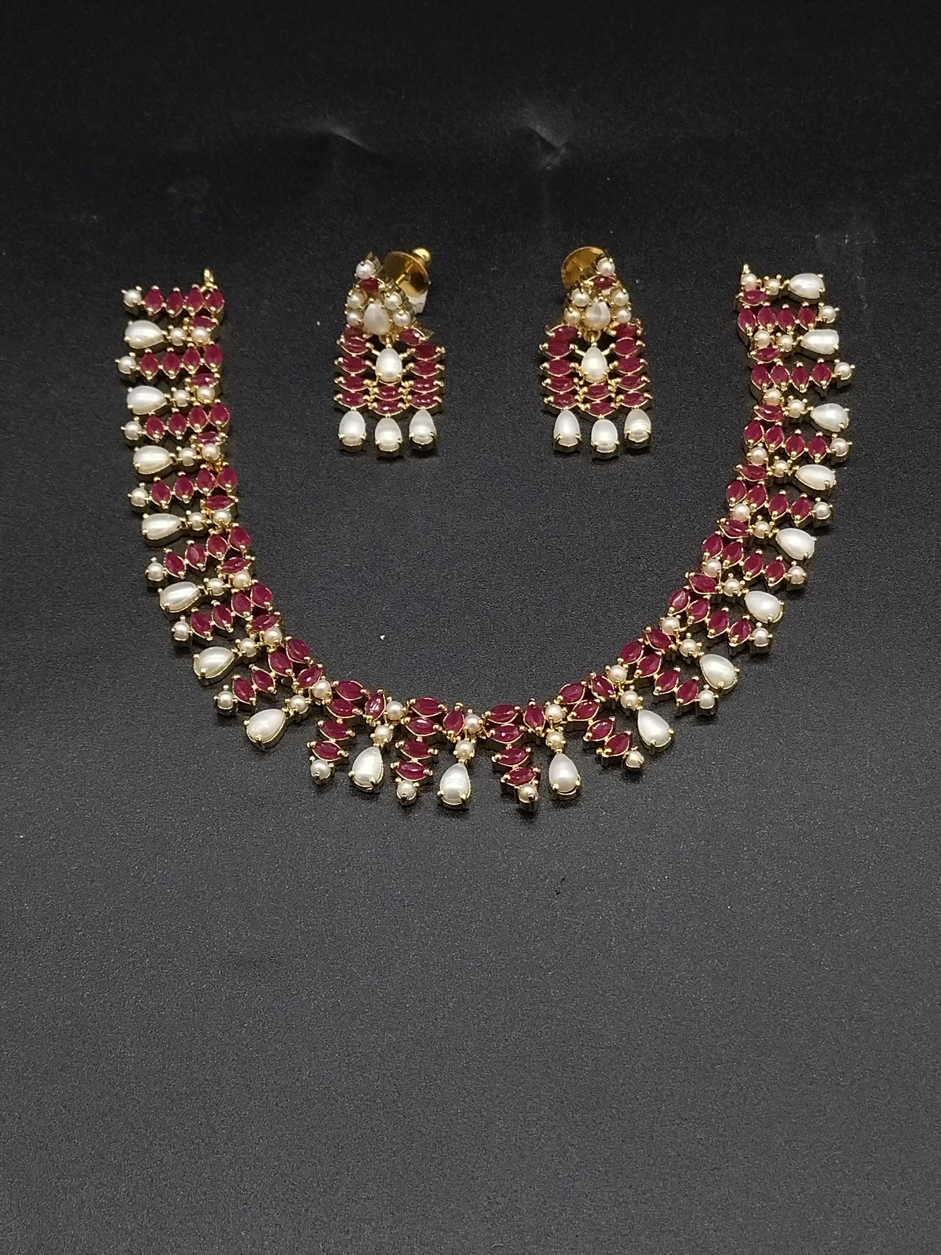 AD stone and freshwater pearl choker set with red American Diamond stones, pearl drops, and matching earrings