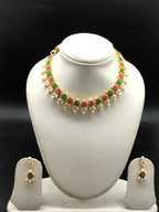 AD stone and freshwater pearl necklace set with red and green American Diamond stones, pearl drops, and matching earrings.