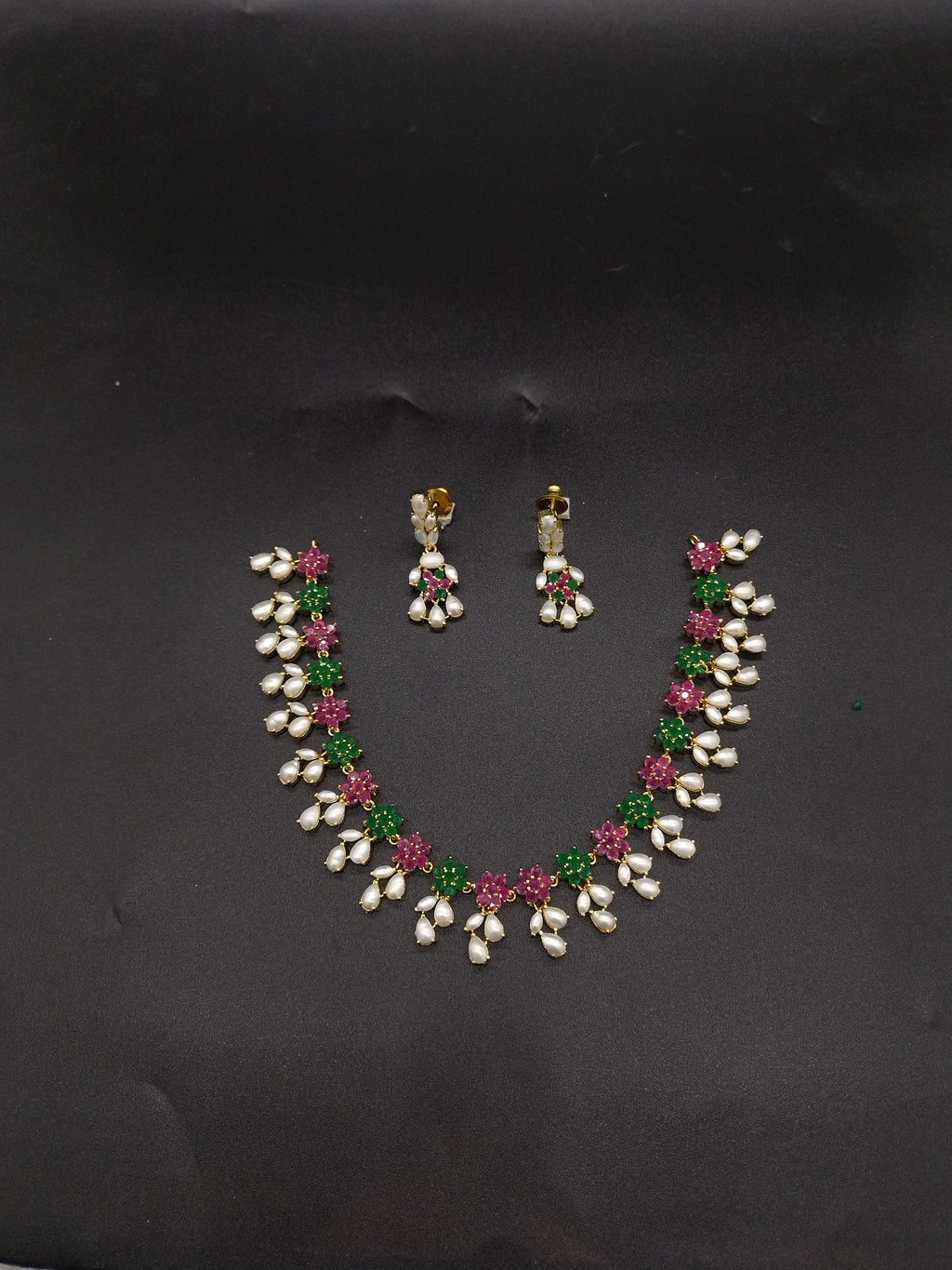 AD stone and freshwater pearl necklace set with red and green American Diamond stones, pearl drops, and matching earrings.