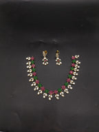 AD stone and freshwater pearl necklace set with red and green American Diamond stones, pearl drops, and matching earrings.