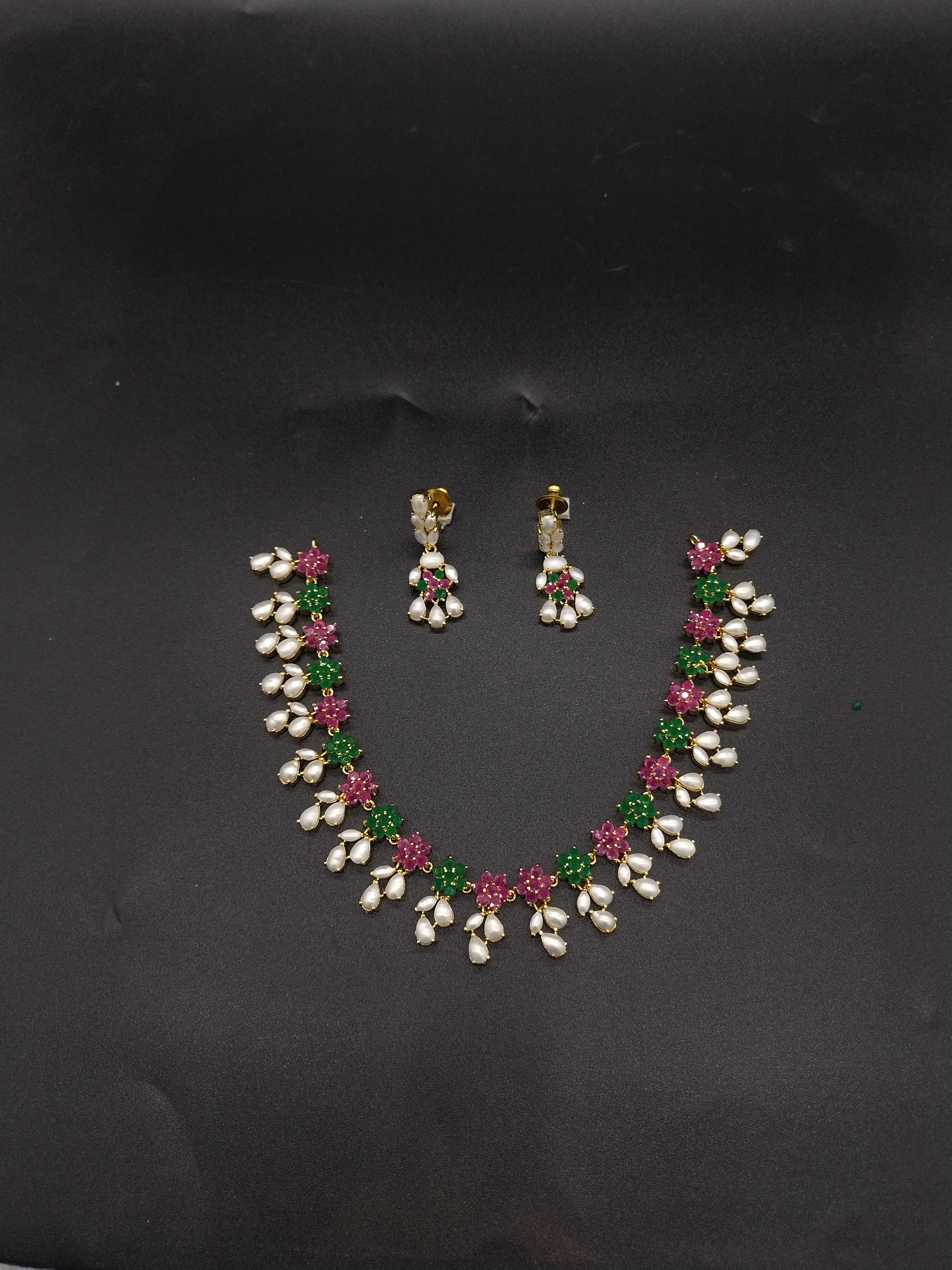AD stone and freshwater pearl necklace set with red and green American Diamond stones, pearl drops, and matching earrings.