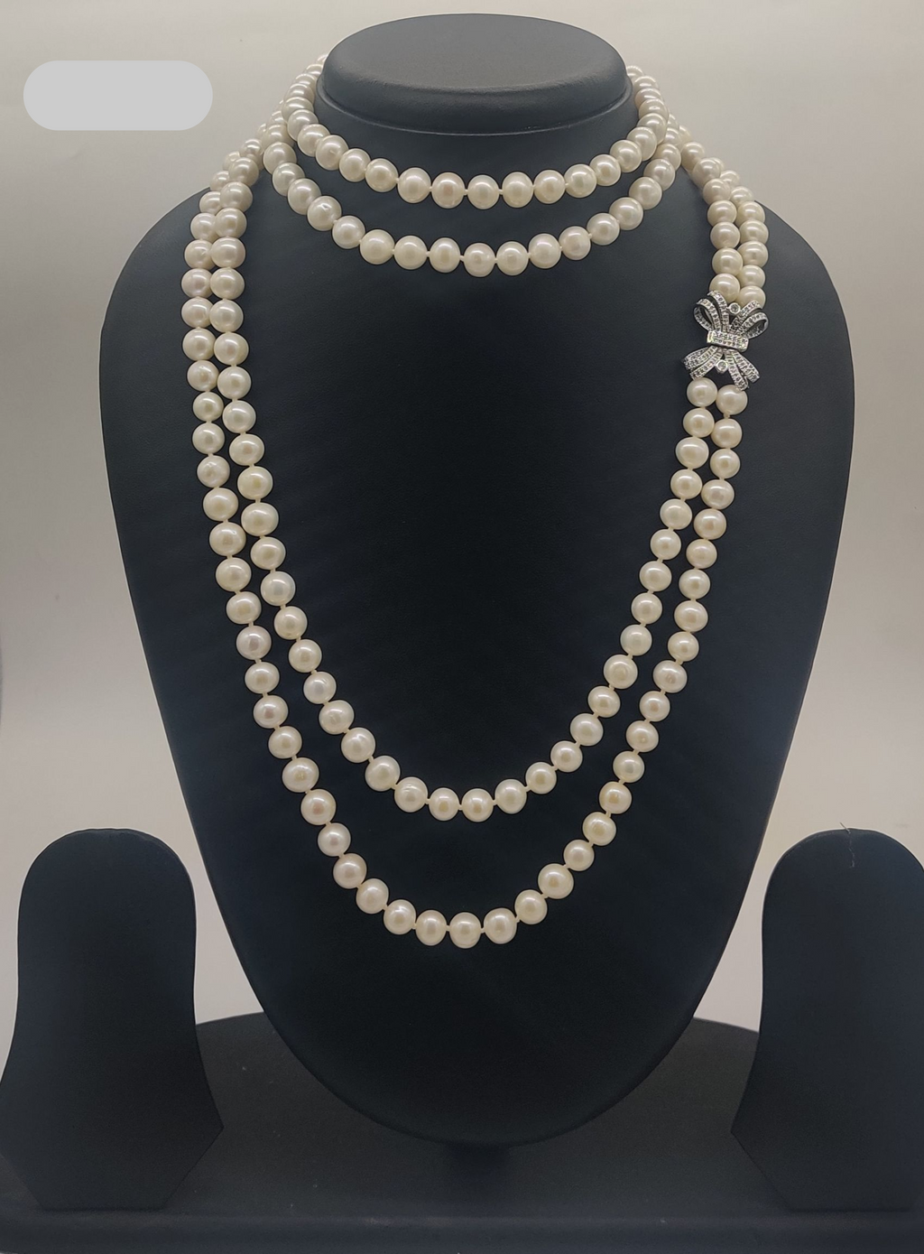 Diamond Bow Grace freshwater pearl necklace set with round white pearls and bow-shaped stone clasp