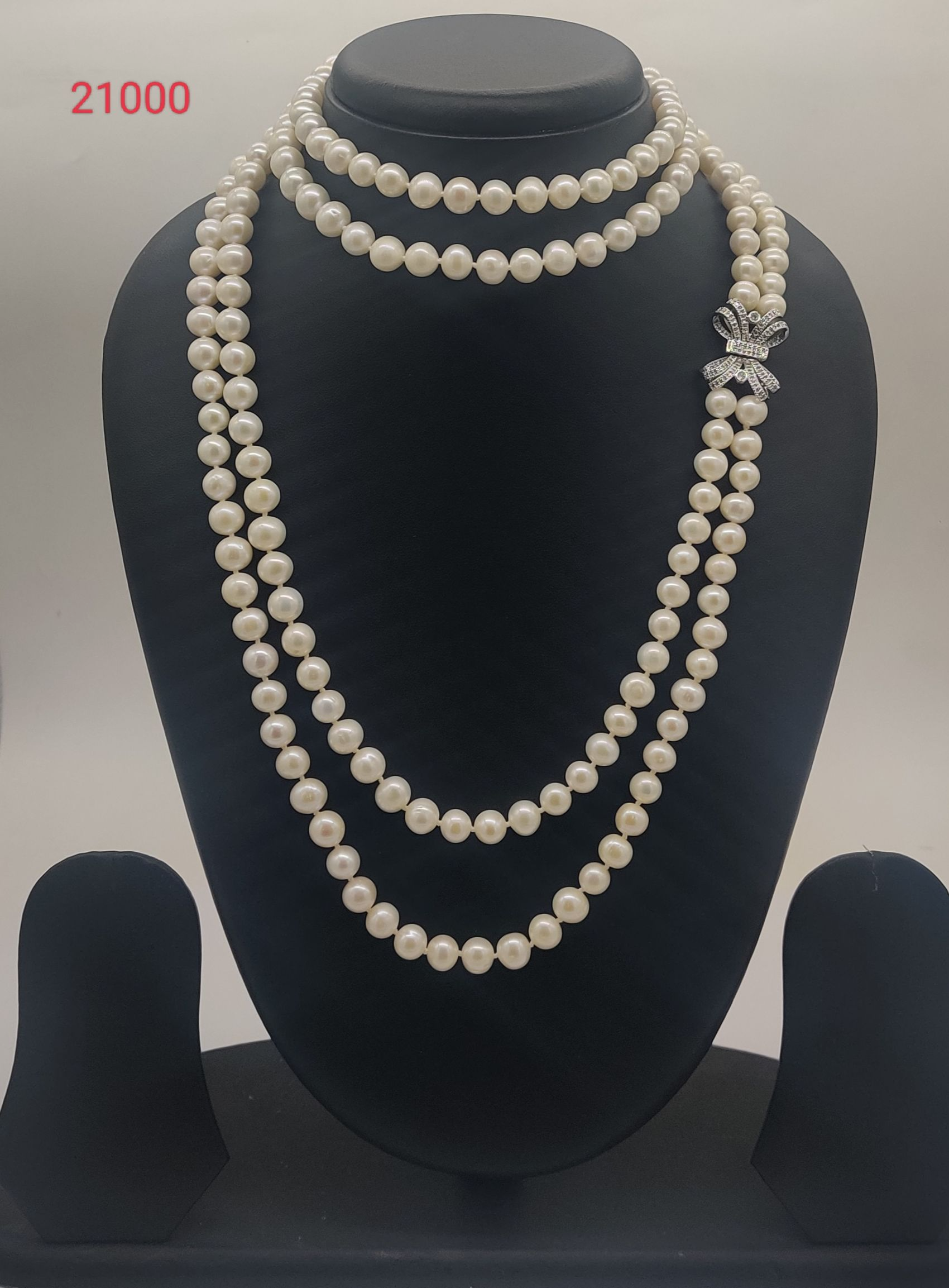 Diamond Bow Grace freshwater pearl necklace set with round white pearls and bow-shaped stone clasp