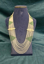 Emerald Royale seven layer fancy pearl necklace with green beads and gold-tone spacers.