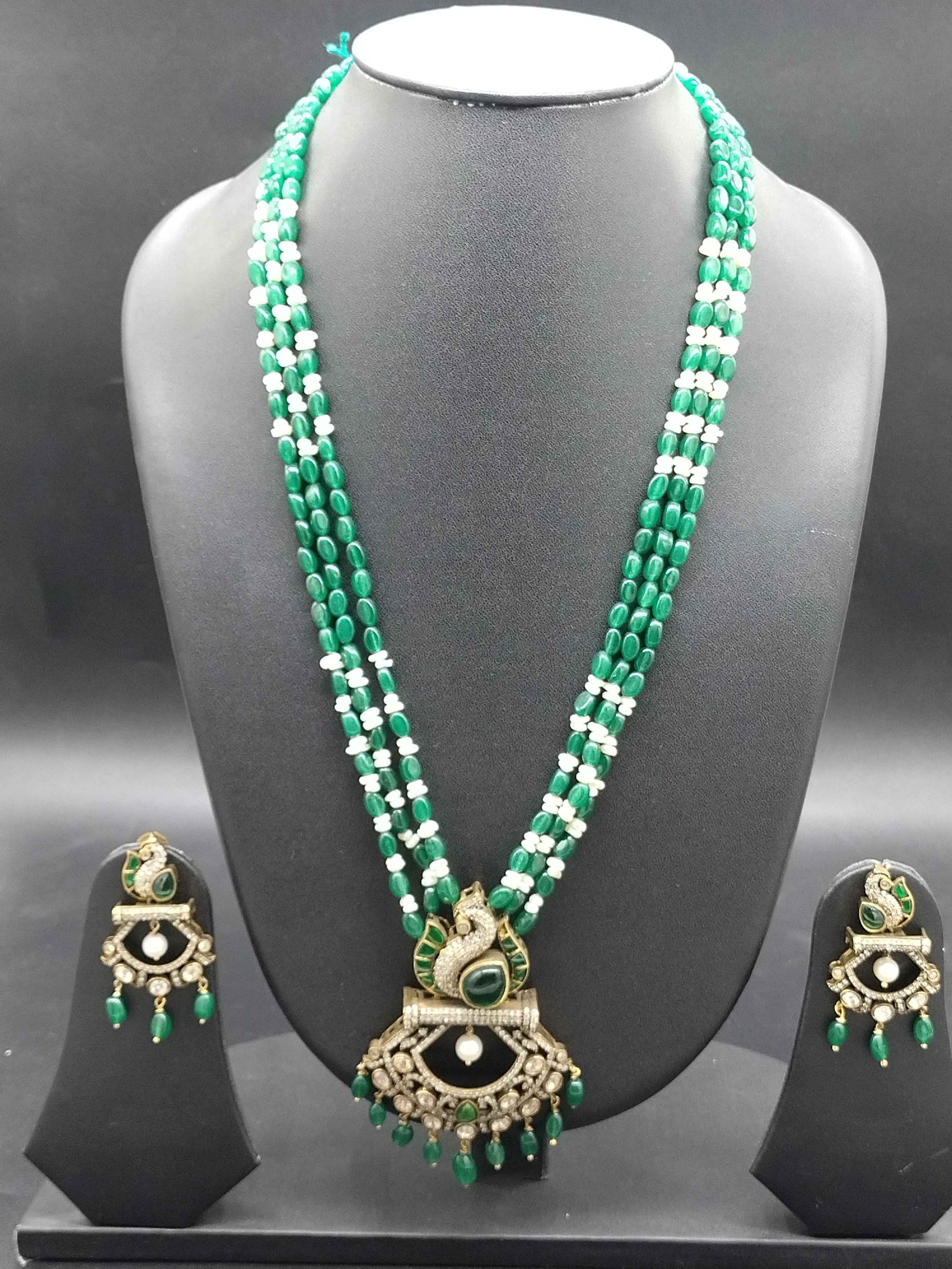 Freshwater pearl and green beads long haram set with peacock pendant and matching earrings.