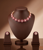 Freshwater pearl choker set with floral red stone motifs, white accents, and matching stud earrings.