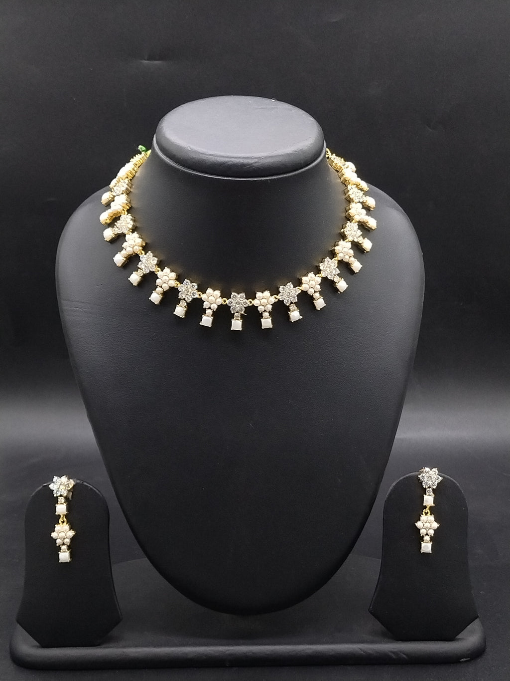 Freshwater pearl choker set with white stone floral motifs and matching earrings.