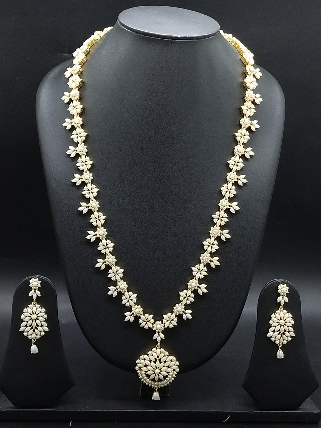 Freshwater pearl long haram set with floral motifs, ornate centerpiece, and matching floral earrings.