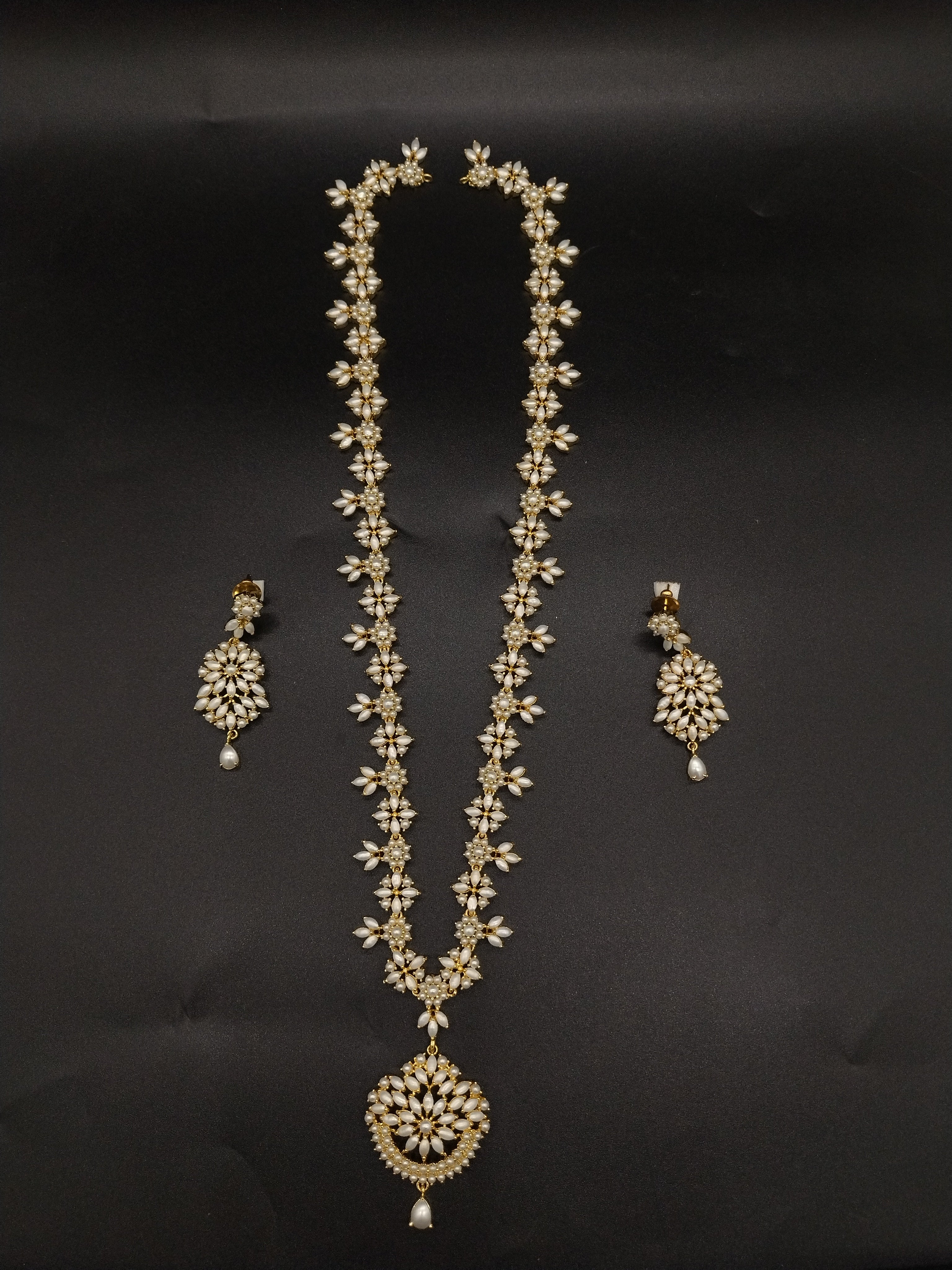 Freshwater pearl long haram set with floral motifs, ornate centerpiece, and matching floral earrings.