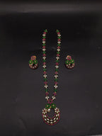 Freshwater pearl long haram set with green and pink stone floral motifs, circular centerpiece, and matching earrings.