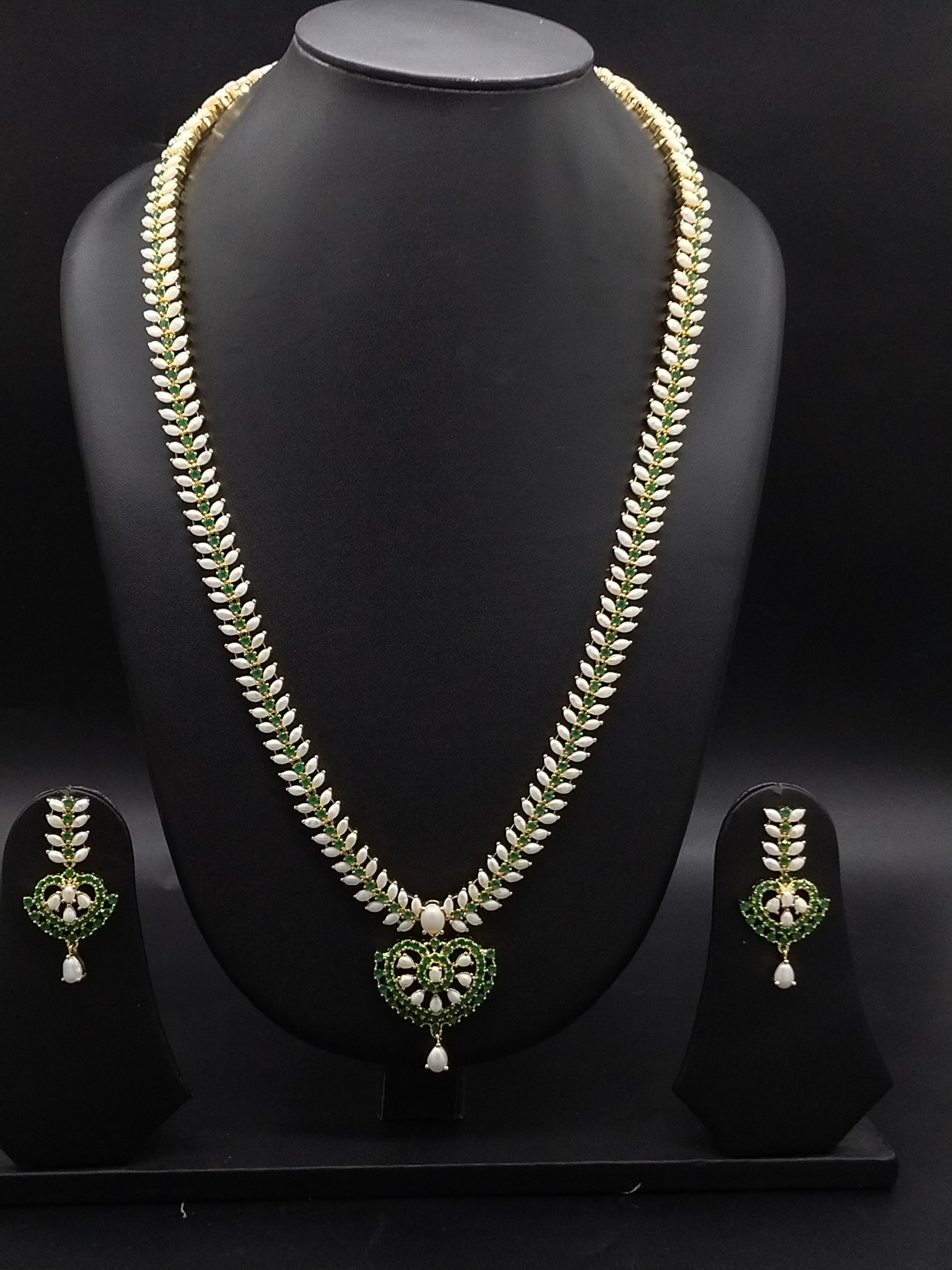 Freshwater pearl long haram set with green stones, floral centerpiece, pearl drop detailing, and matching earrings.