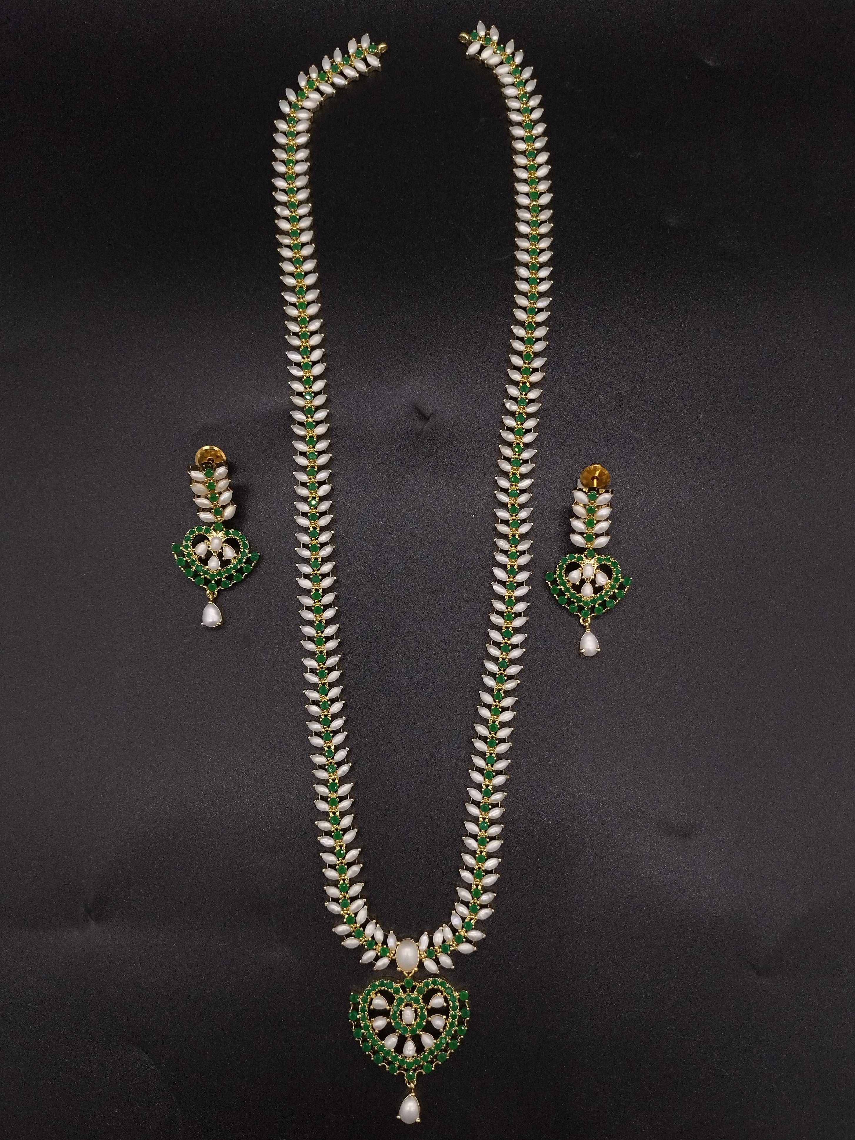 Freshwater pearl long haram set with green stones, floral centerpiece, pearl drop detailing, and matching earrings.