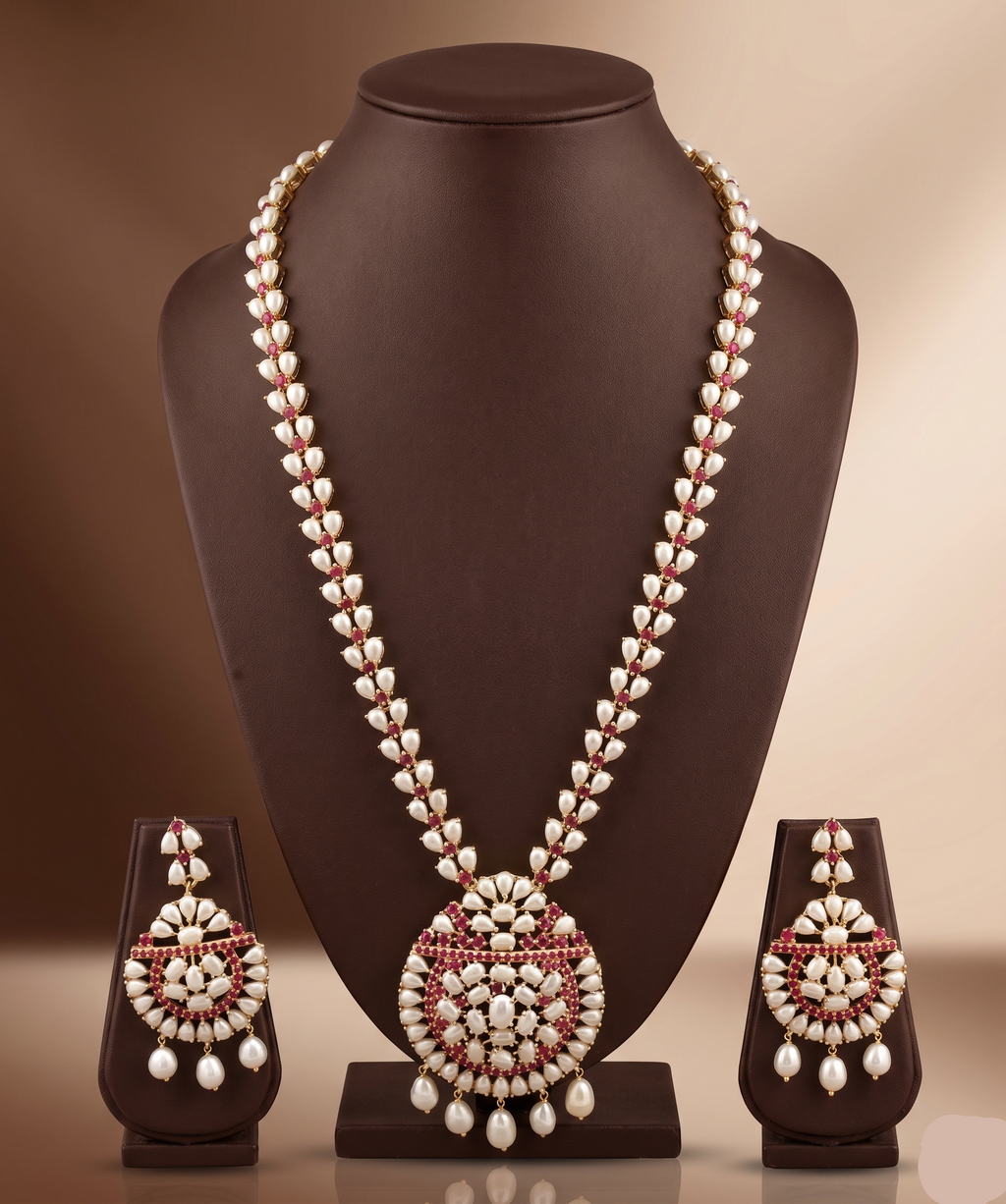 Freshwater pearl long haram set with red and white stone floral motifs, circular pendant with pearl drops, and matching earrings.