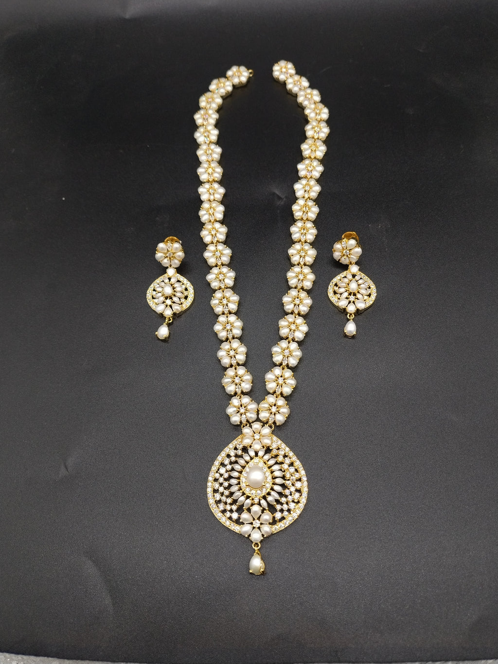 Freshwater pearl long haram set with white AD stones, mandala-style pearl centerpiece, and matching earrings.