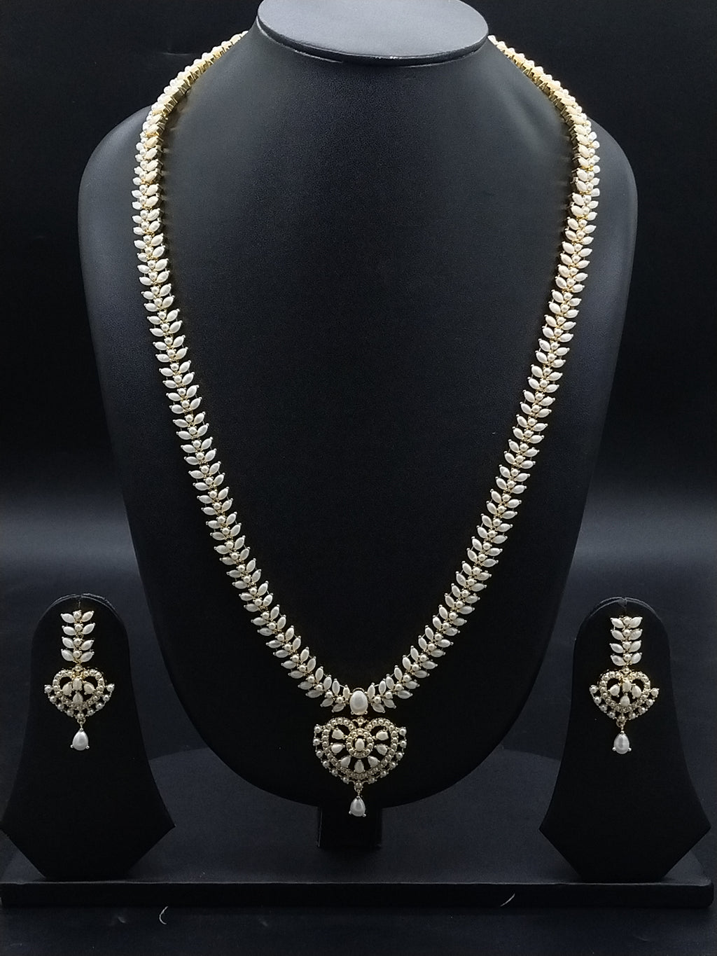 Freshwater pearl long haram set with white AD stones, ornate medallion pendant, pearl drop detailing, and matching earrings.