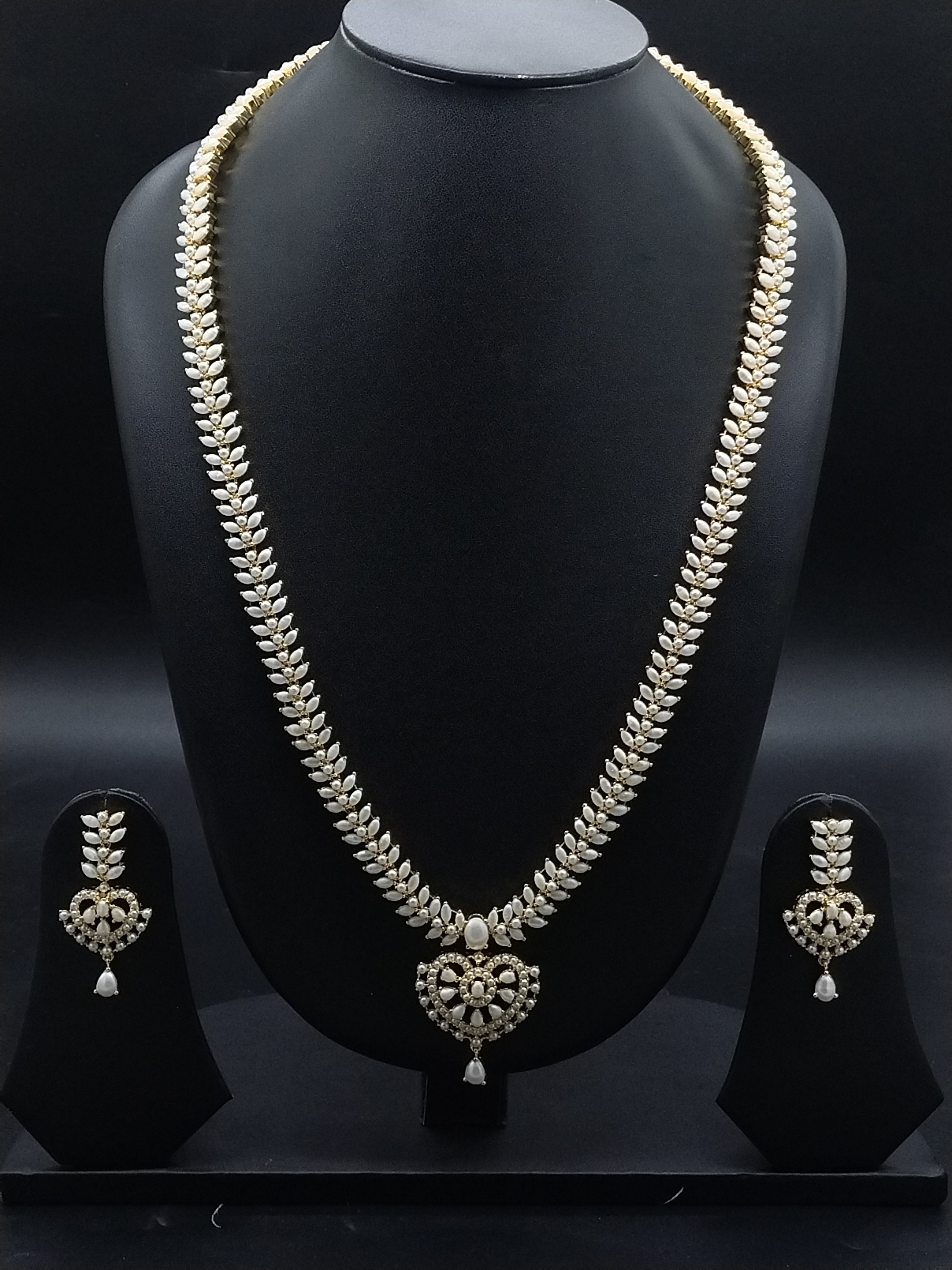 Freshwater pearl long haram set with white AD stones, ornate medallion pendant, pearl drop detailing, and matching earrings.