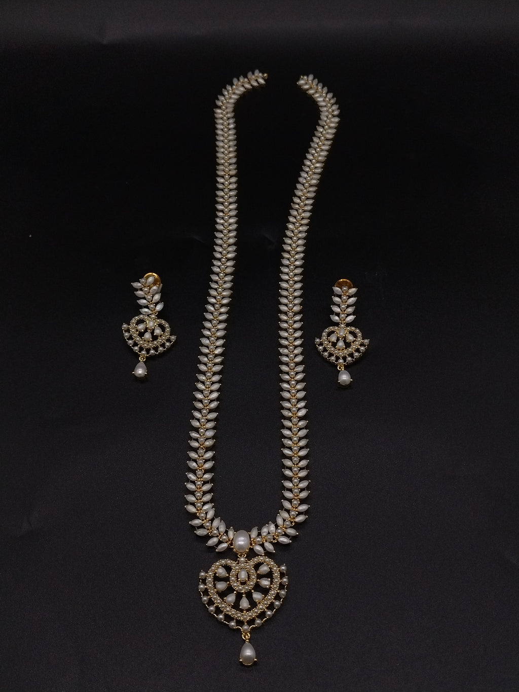 Freshwater pearl long haram set with white AD stones, ornate medallion pendant, pearl drop detailing, and matching earrings.