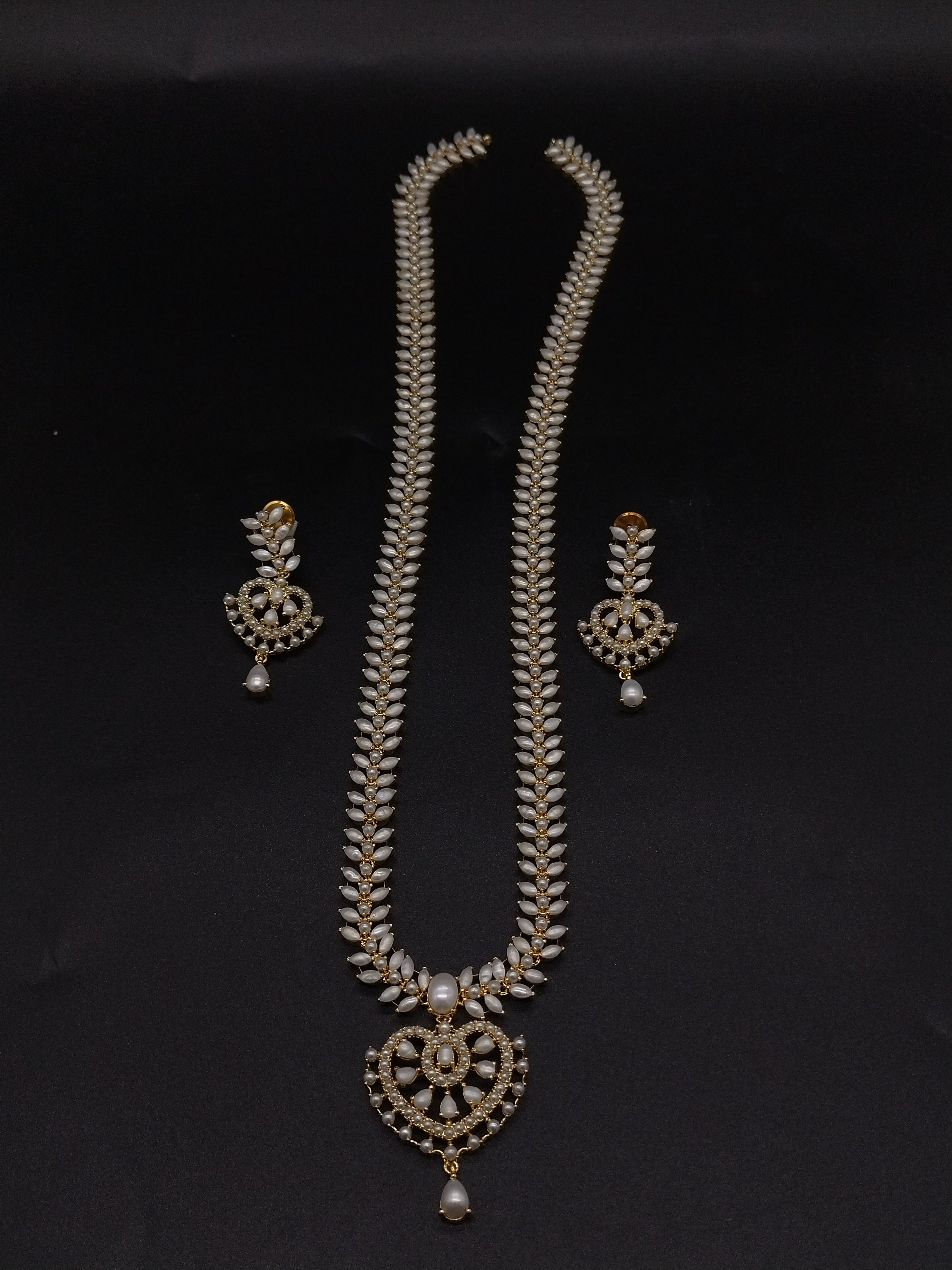 Freshwater pearl long haram set with white AD stones, ornate medallion pendant, pearl drop detailing, and matching earrings.