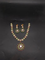 Freshwater pearl necklace set with floral red and green stone pendant and matching earrings.