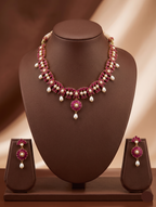 Freshwater pearl necklace set with red stone floral centerpiece, pearl drop detailing, and matching earrings.