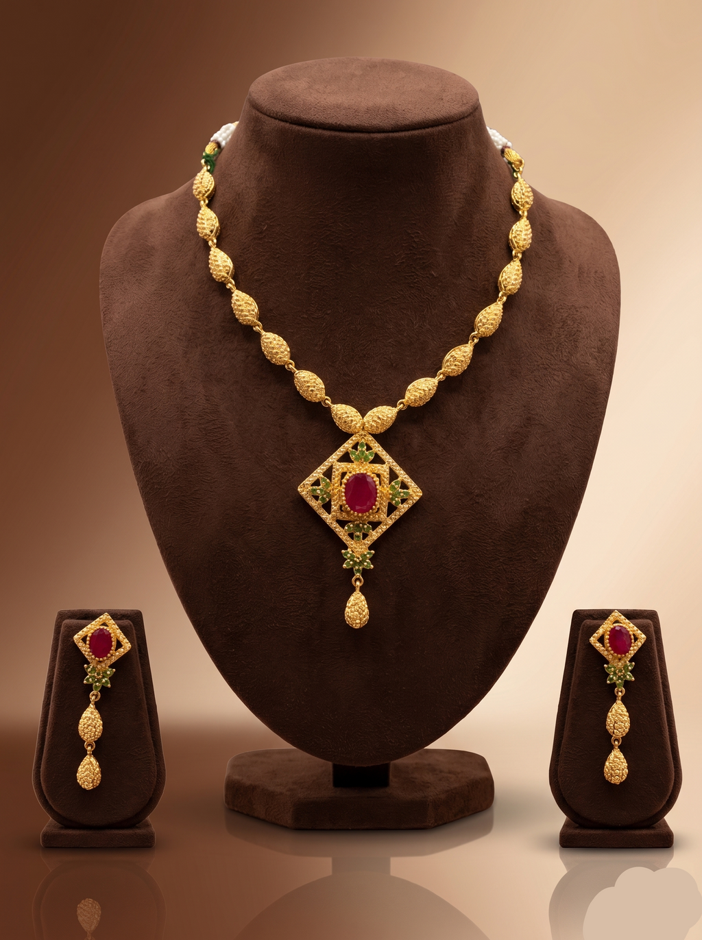 Freshwater pearl necklace set with ruby red and emerald green stones, diamond-shaped pendant, and matching hanging earrings.