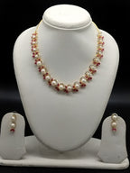 Freshwater pearl necklace set with ruby red stones, white American Diamond accents, and matching drop earrings.