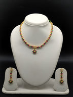 Green and red stone pearl necklace set with floral choker design, freshwater pearls, and matching drop earrings.