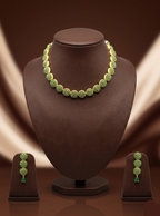 Green stone designer necklace set with circular motifs and matching drop earrings.
