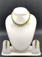 Green stone designer necklace set with circular motifs and matching drop earrings.