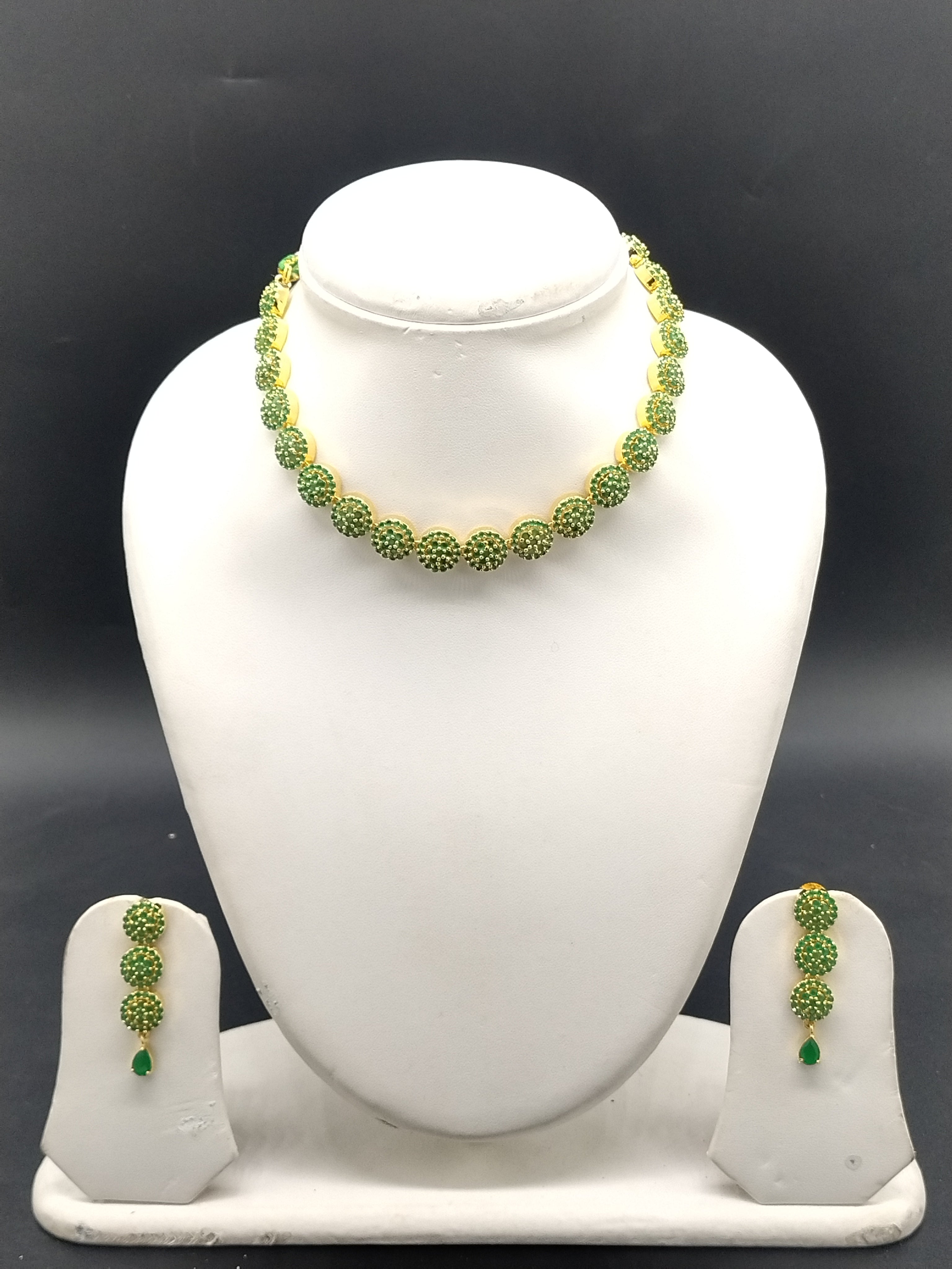 Green stone designer necklace set with circular motifs and matching drop earrings.