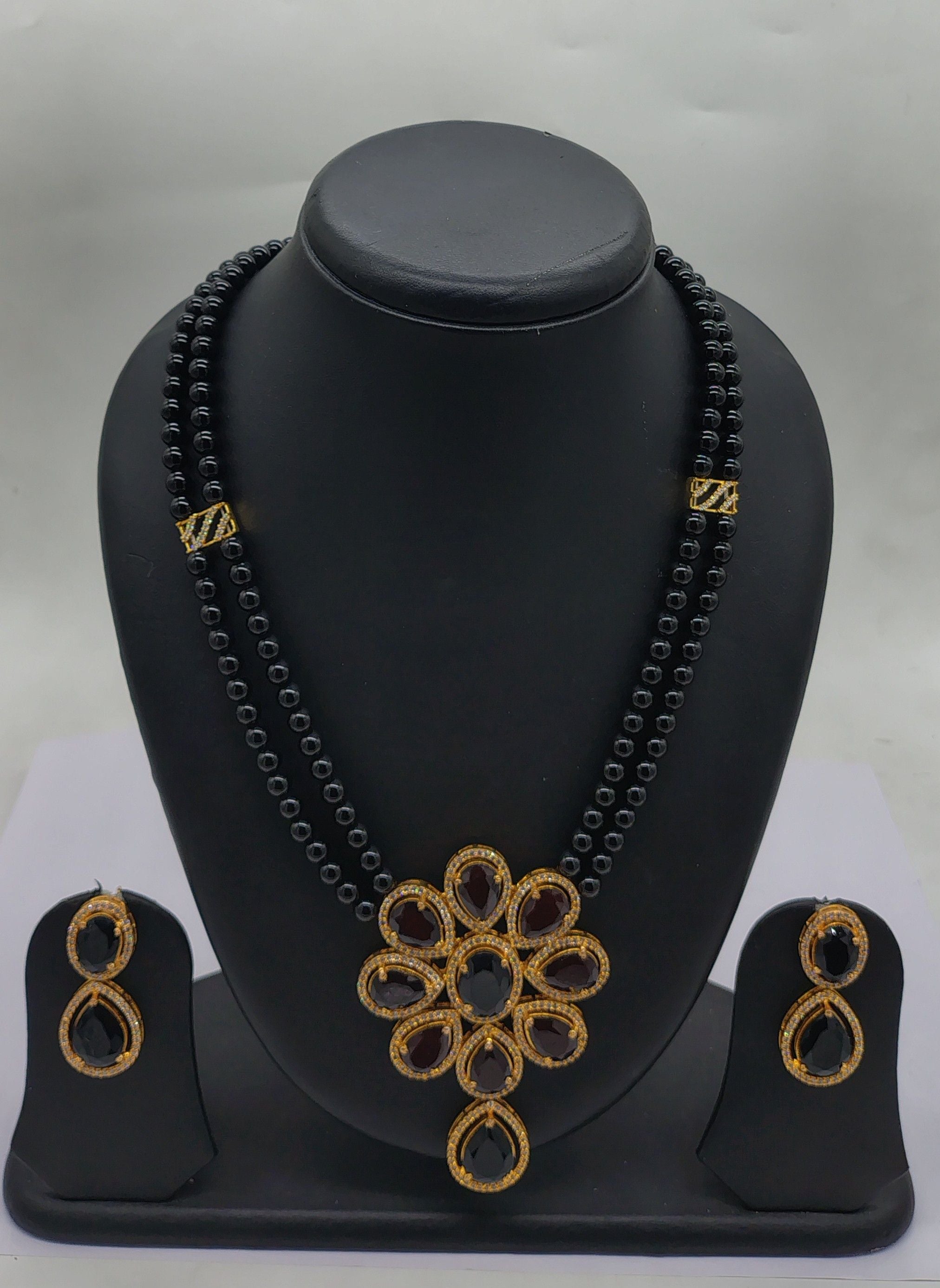 Midnight Blossom two-line black freshwater pearl pendant necklace and earrings set with floral black stone