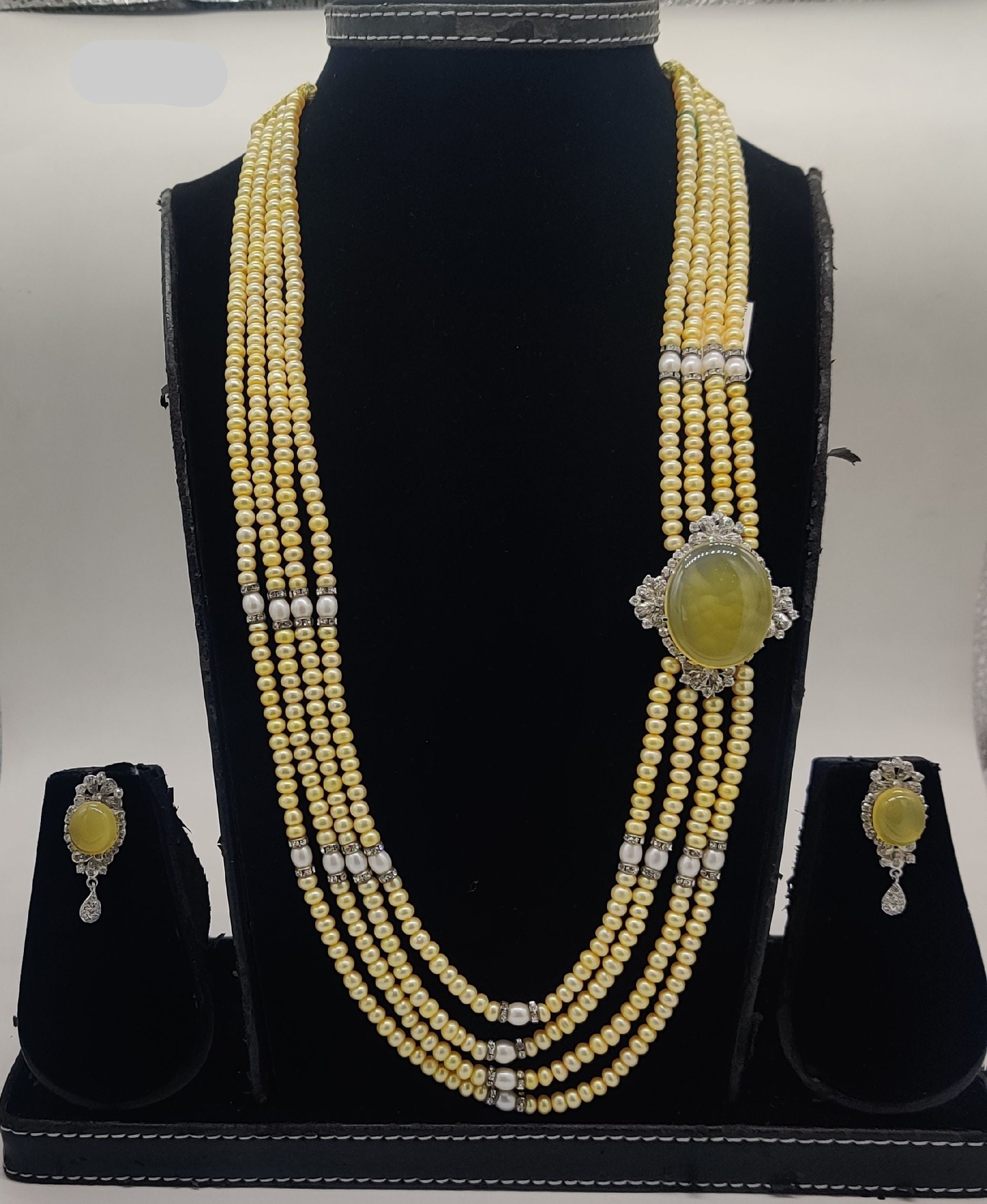 Four-line freshwater yellow pearl broach set with oval citrine-tone gemstone and silver detailing with matching earrings.