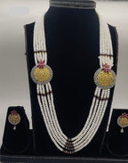 Five-line freshwater pearl broach set with gold temple medallions and pink ruby-tone stones with matching earrings.