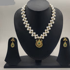 Golden emerald glow two-strand freshwater pearl necklace set with round gold pendant and green gemstone detailing