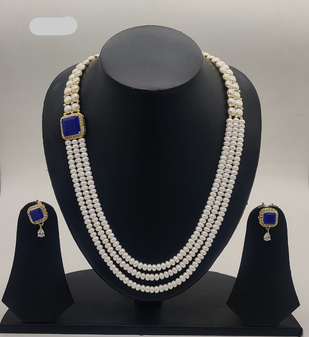 Multi-line freshwater pearl broach set with square sapphire-blue stone centerpiece and matching stud earrings.
