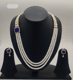 Multi-line freshwater pearl broach set with square sapphire-blue stone centerpiece and matching stud earrings.