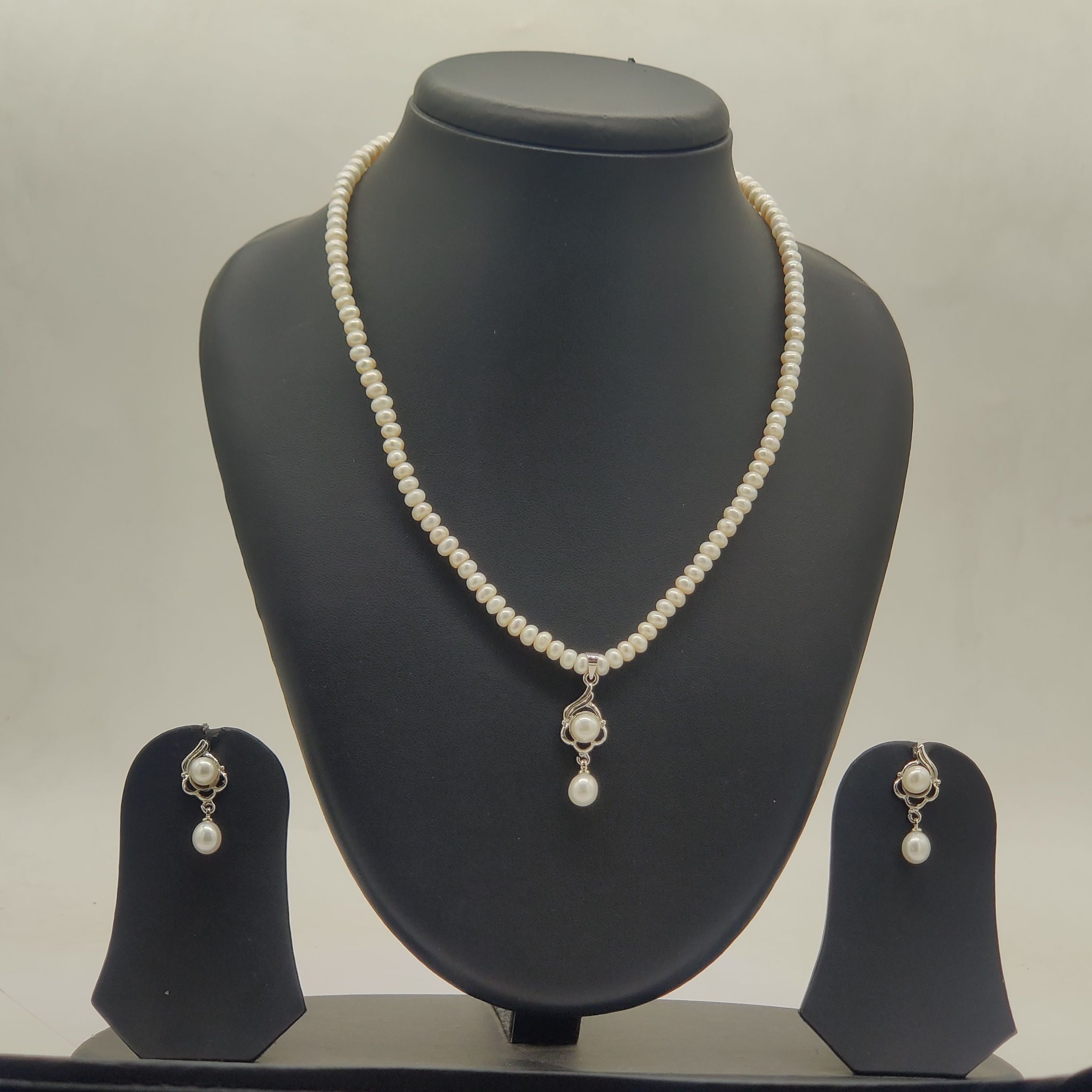 One line freshwater pearl necklace and earrings set with white pearls and central larger pearl pendant