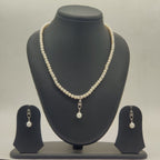One line freshwater pearl necklace and earrings set with larger pearl drop pendant and silver toned detailing
