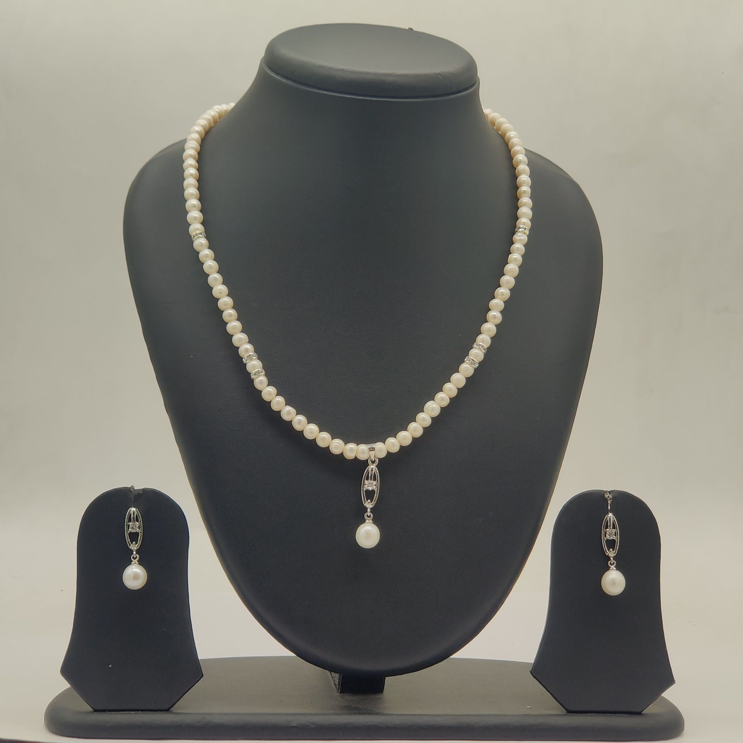 One line freshwater pearl necklace and earrings set with larger pearl drop pendant and silver toned detailing