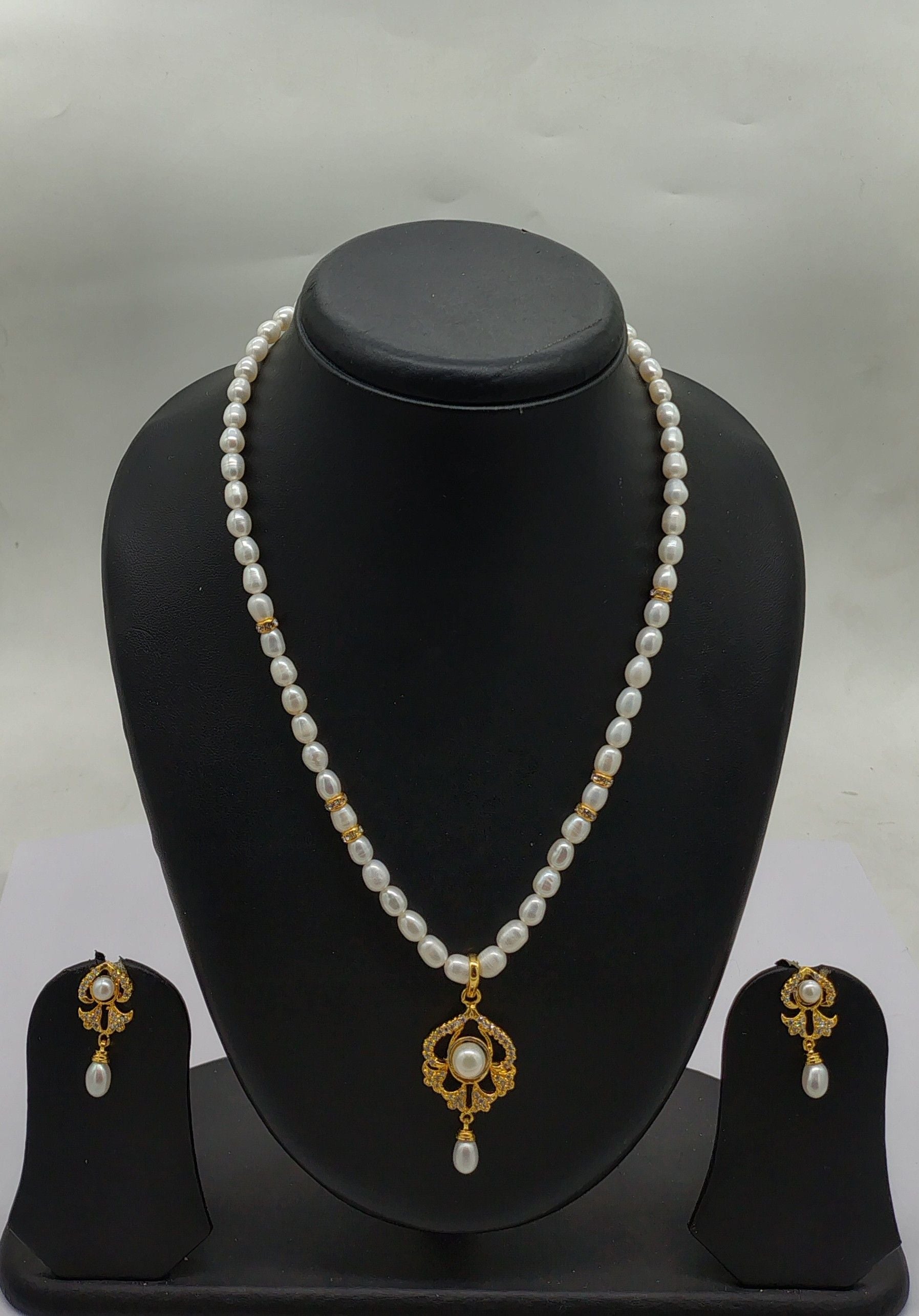 One line freshwater pearl necklace and earrings set with sculpted teardrop pendant and gold-accented pearls