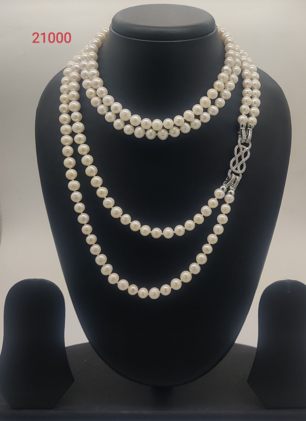 Opulent Layered Crest freshwater pearl necklace set with layered round white pearls and ornate stone clasp