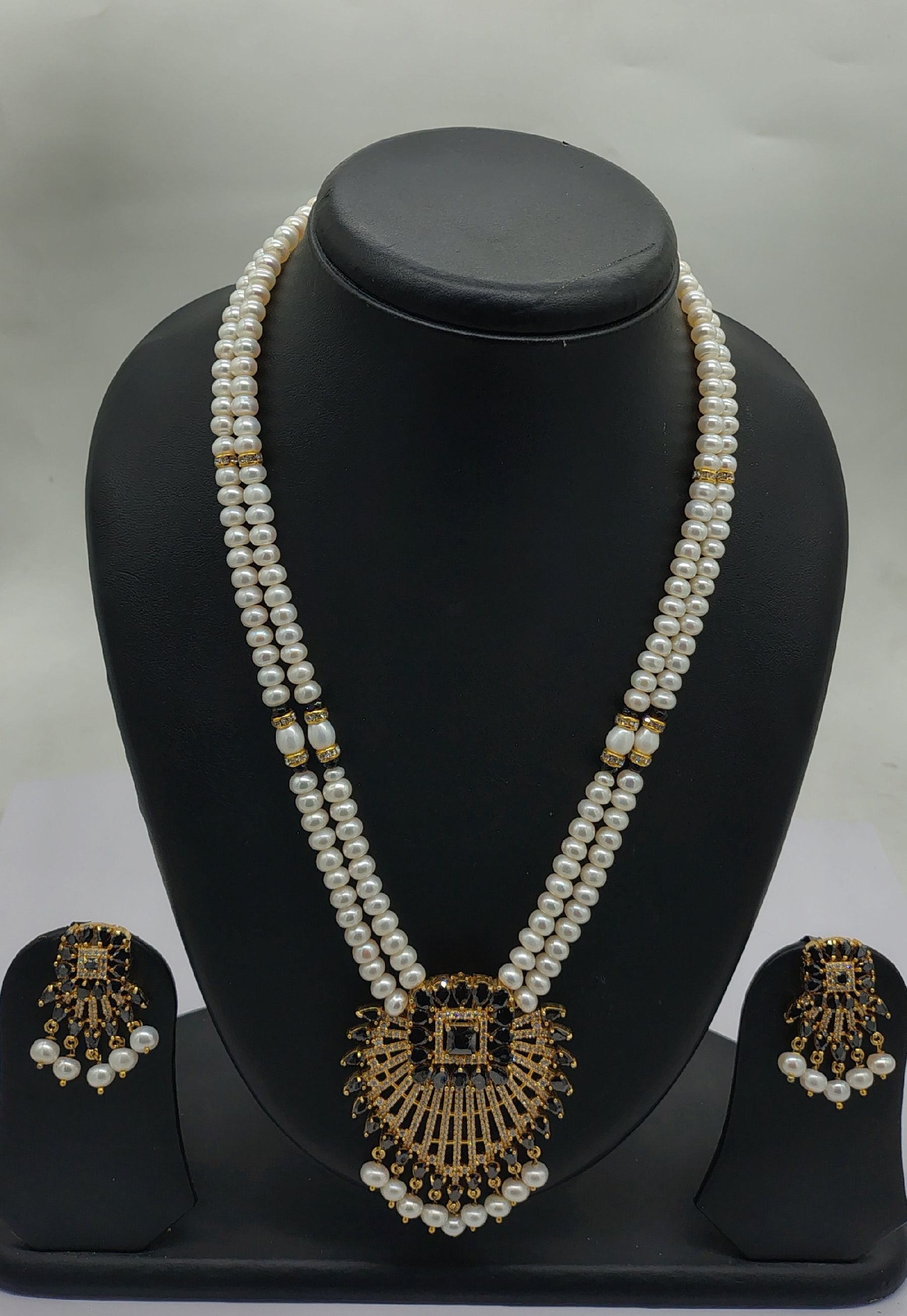 Regal Pearl Noir two line freshwater pearl pendant necklace set with flat white pearls and black gold centerpiece