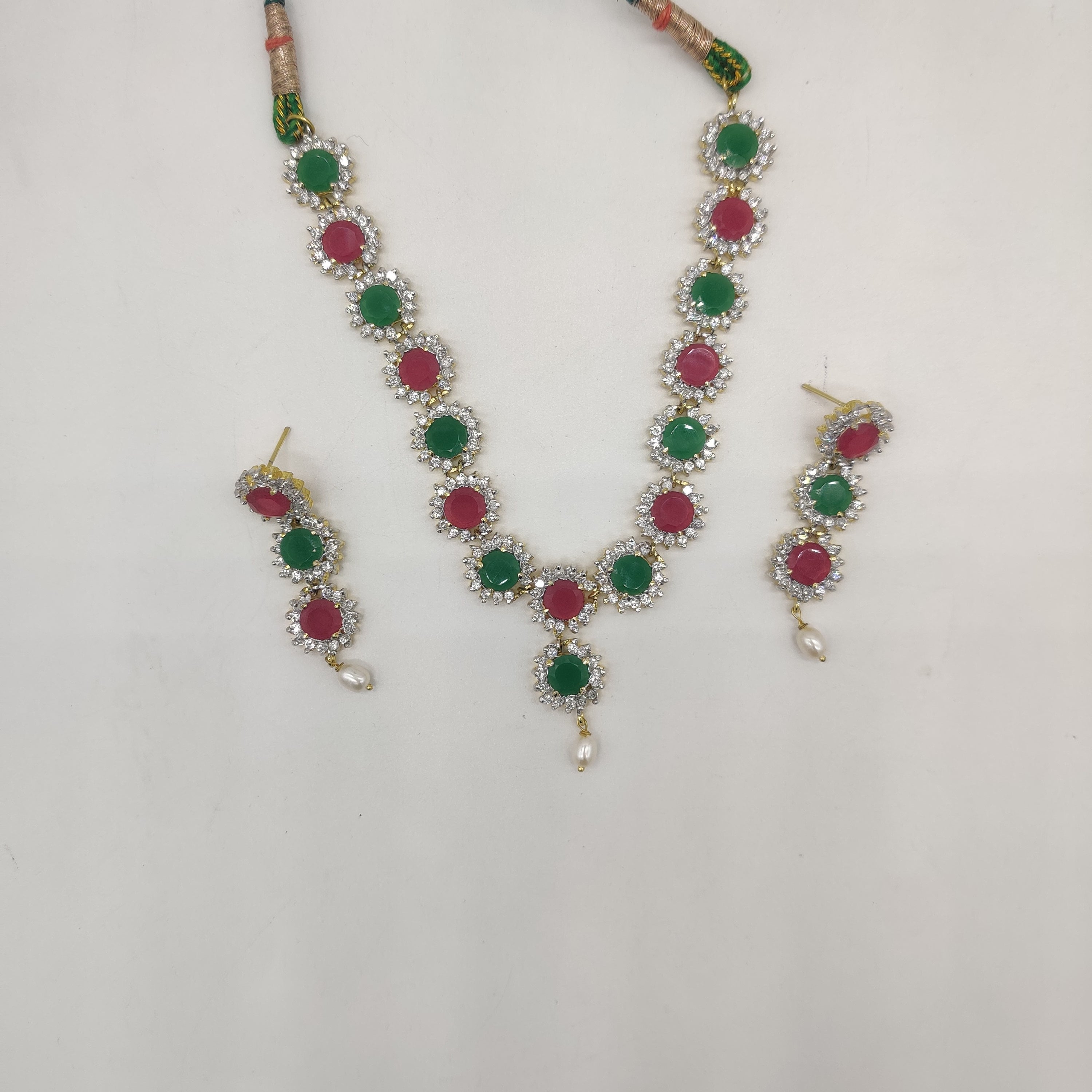 Royal Bloom multicolour CZ necklace set with floral design, pearl accent, and matching three-tier earrings.