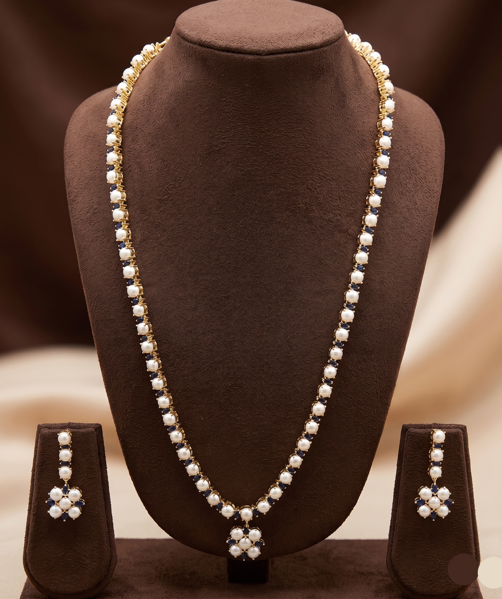 Single-line freshwater pearl long haram set with blue stone floral centerpiece and matching drop earrings.
