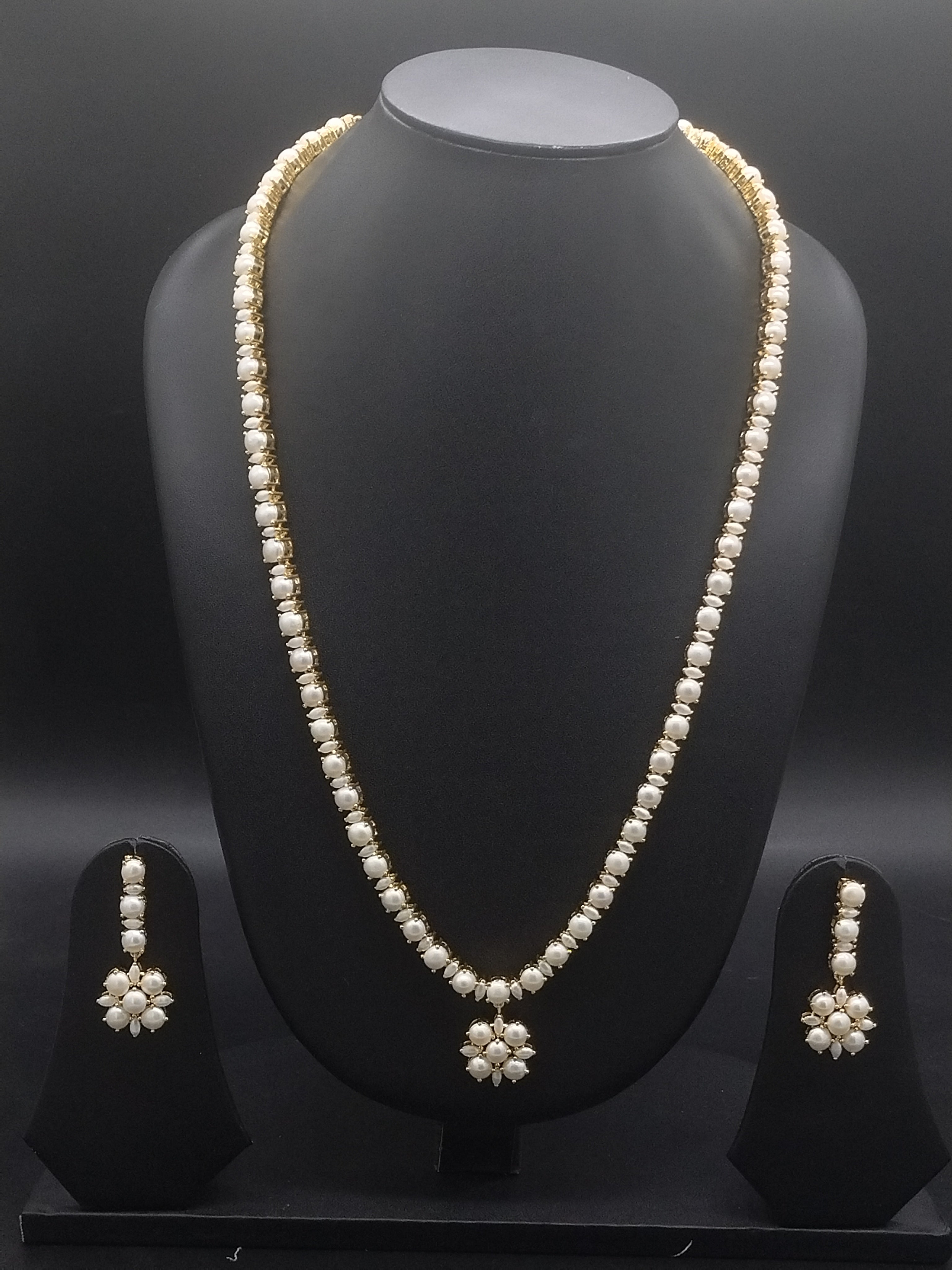 Single-line freshwater pearl long haram set with floral pearl centerpiece and matching drop earrings.