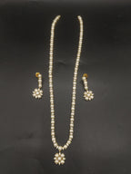 Single-line freshwater pearl long haram set with floral pearl centerpiece and matching drop earrings.