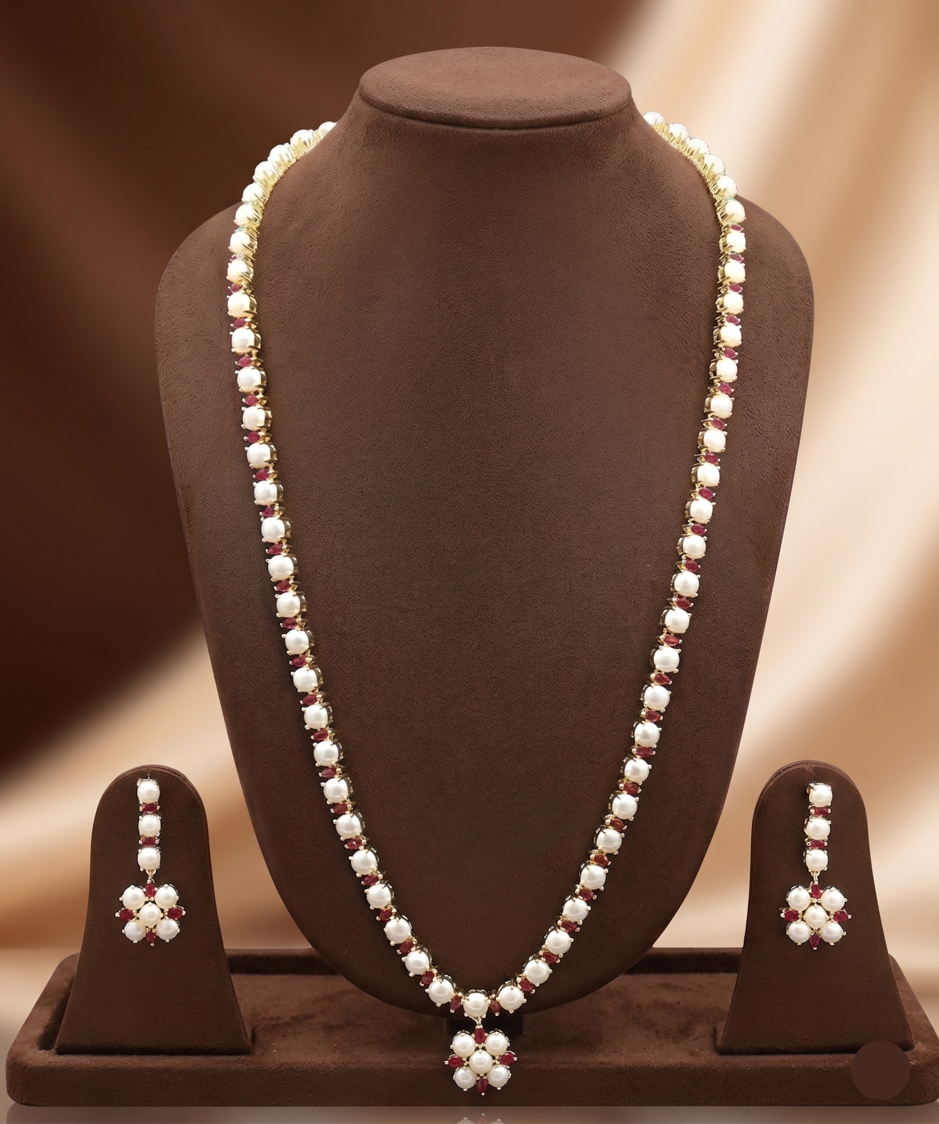 Single-line freshwater pearl long haram set with floral pearl pendant, red American Diamond stone accents, and matching earrings.