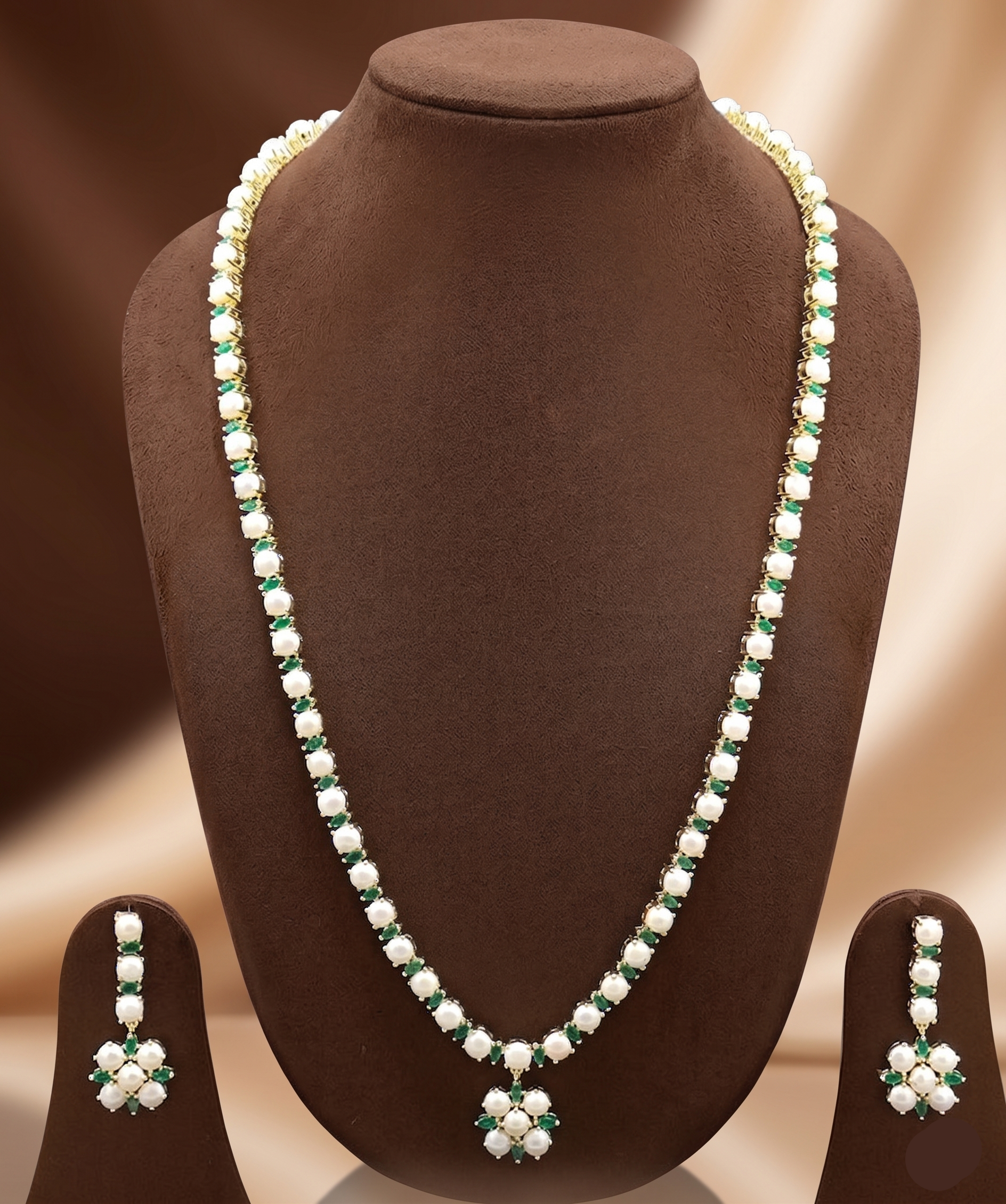 Single-line freshwater pearl long haram set with green stone floral pendant and matching drop earrings.