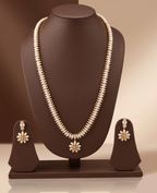 Three-line freshwater pearl long haram set with sunburst floral pendant and matching floral earrings.